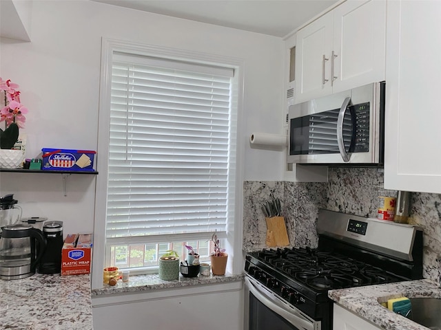 141-35 79th Ave Unit 3M, Flushing, NY 11367 - kitchen with stainless steel appliances, white cabinets, backsplash, and light stone countertops