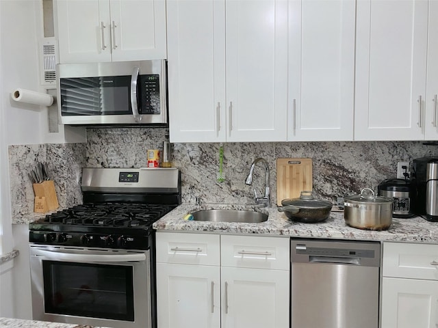 141-35 79th Ave Unit 3M, Flushing, NY 11367 - kitchen with stainless steel appliances, white cabinets, backsplash, and light stone countertops