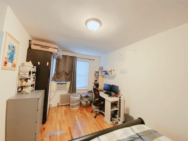 141-35 79th Ave Unit 3M, Flushing, NY 11367 - bedroom with light wood finished floors, radiator, an office area, a wall unit AC, and cooling unit