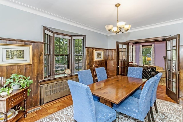 25 Reyam Rd, Lynbrook, NY 11563 - dining space featuring a chandelier, wooden walls, ornamental molding, radiator, and french doors