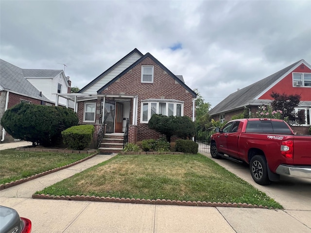 48 Wellington Rd, Elmont, NY 11003 - bungalow-style house featuring brick siding and a front yard
