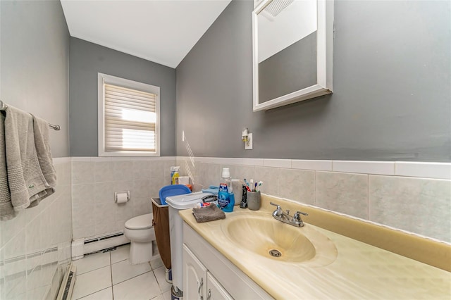 1002 Park Ave, Westbury, NY 11590 - bathroom with baseboard heating, vanity, tile patterned floors, tile walls, and a wainscoted wall