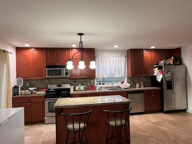 616 Port Richmond Ave, Staten Island, NY 10302 - kitchen featuring appliances with stainless steel finishes, backsplash, hanging light fixtures, recessed lighting, and a breakfast bar area