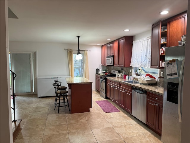 616 Port Richmond Ave, Staten Island, NY 10302 - kitchen featuring stainless steel appliances, a breakfast bar, decorative backsplash, a center island, and decorative light fixtures