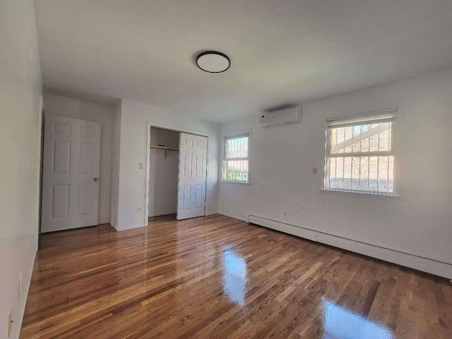 20-45 120th St, College Point, NY 11356 - unfurnished bedroom with a wall mounted AC, baseboard heating, wood finished floors, and a closet