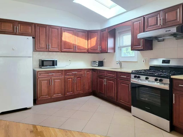20-45 120th St, College Point, NY 11356 - kitchen with stainless steel appliances, under cabinet range hood, a skylight, light countertops, and lofted ceiling