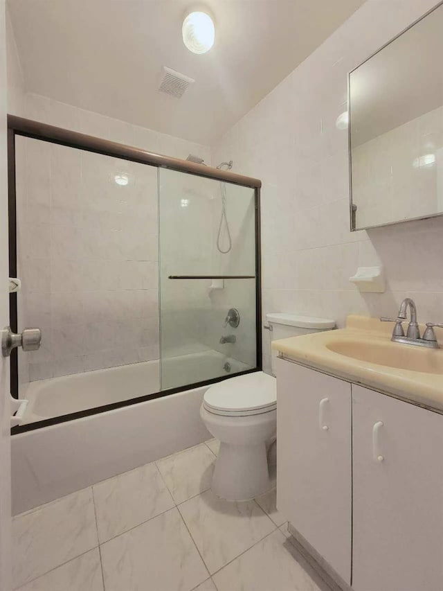 20-45 120th St, College Point, NY 11356 - bathroom with vanity, combined bath / shower with glass door, marble look tiles, and tile walls