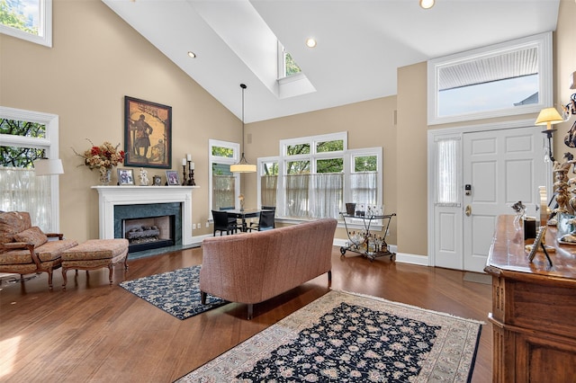 48 Fieldstone Ln, Oyster Bay, NY 11771 - living room featuring high vaulted ceiling, a skylight, wood finished floors, a fireplace with flush hearth, and recessed lighting