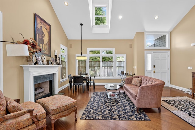 48 Fieldstone Ln, Oyster Bay, NY 11771 - living area featuring high vaulted ceiling, plenty of natural light, wood finished floors, a skylight, and a fireplace