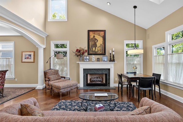 48 Fieldstone Ln, Oyster Bay, NY 11771 - living room featuring high vaulted ceiling, a fireplace, decorative columns, and wood finished floors