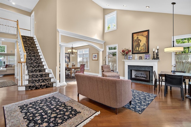 48 Fieldstone Ln, Oyster Bay, NY 11771 - living area with high vaulted ceiling, decorative columns, stairway, healthy amount of natural light, and a fireplace with flush hearth