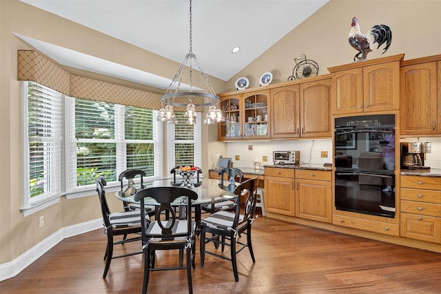 48 Fieldstone Ln, Oyster Bay, NY 11771 - dining space featuring vaulted ceiling, dark wood-style floors, and a chandelier