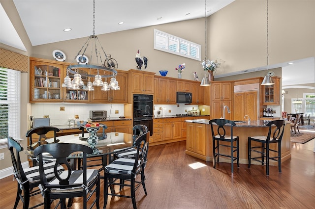 48 Fieldstone Ln, Oyster Bay, NY 11771 - kitchen featuring black appliances, high vaulted ceiling, dark wood-style flooring, brown cabinetry, and glass insert cabinets