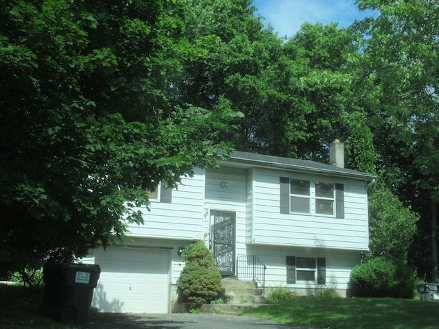 109 Indian Trl, Montgomery, NY 12543 - bi-level home featuring a garage, a chimney, and driveway