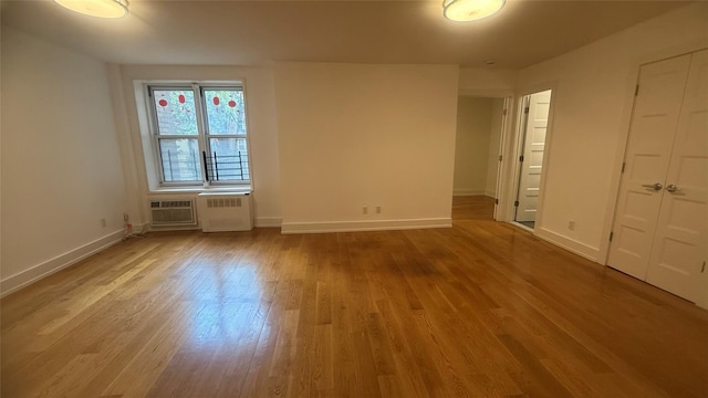 142-20 Franklin Ave Unit 3V, Flushing, NY 11355 - unfurnished bedroom featuring wood finished floors, a wall mounted air conditioner, and radiator