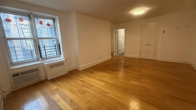 142-20 Franklin Ave Unit 3V, Flushing, NY 11355 - spare room featuring radiator heating unit, light wood-style flooring, and an AC wall unit
