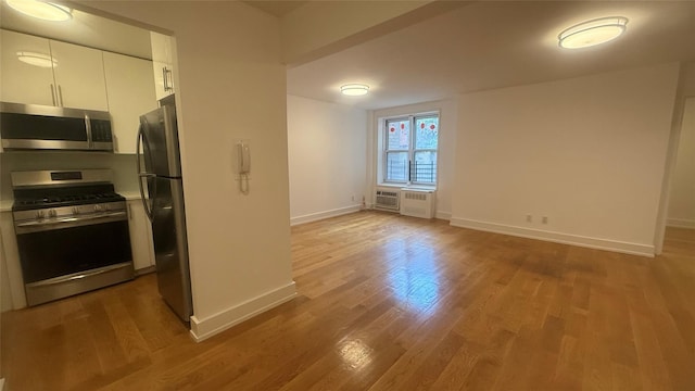 142-20 Franklin Ave Unit 3V, Flushing, NY 11355 - kitchen featuring appliances with stainless steel finishes, white cabinetry, light countertops, and wood finished floors