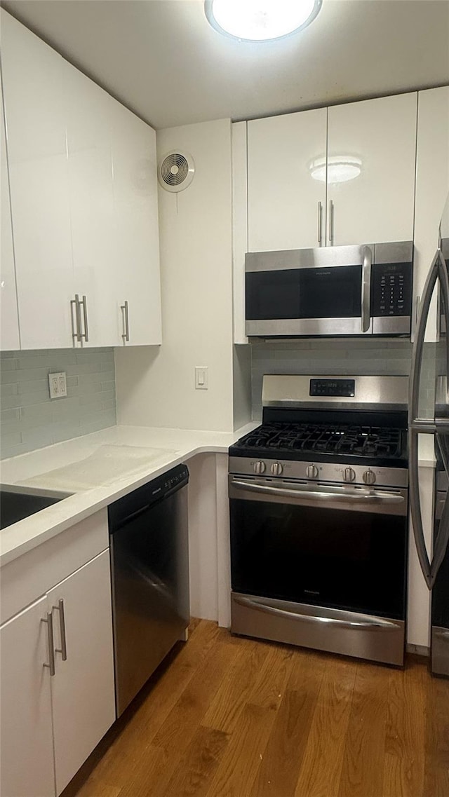142-20 Franklin Ave Unit 3V, Flushing, NY 11355 - kitchen featuring stainless steel appliances, light wood-style floors, white cabinets, and light countertops