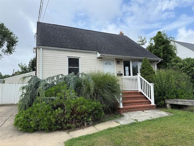 449 N Indiana Ave, Lindenhurst, NY 11757 - view of front of home featuring roof with shingles and a chimney