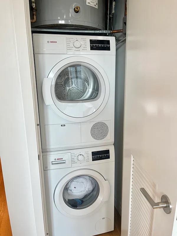 24-16 Queens Plz S Unit 4J, Long Island City, NY 11101 - laundry room with stacked washer and clothes dryer