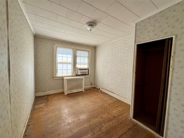 10221 Davenport Ct, Howard Beach, NY 11414 - unfurnished bedroom featuring hardwood / wood-style flooring, wallpapered walls, radiator, crown molding, and cooling unit