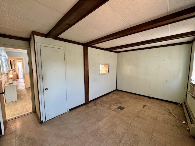 10221 Davenport Ct, Howard Beach, NY 11414 - unfurnished bedroom with tile patterned floors, beamed ceiling, wooden walls, baseboard heating, and a textured ceiling