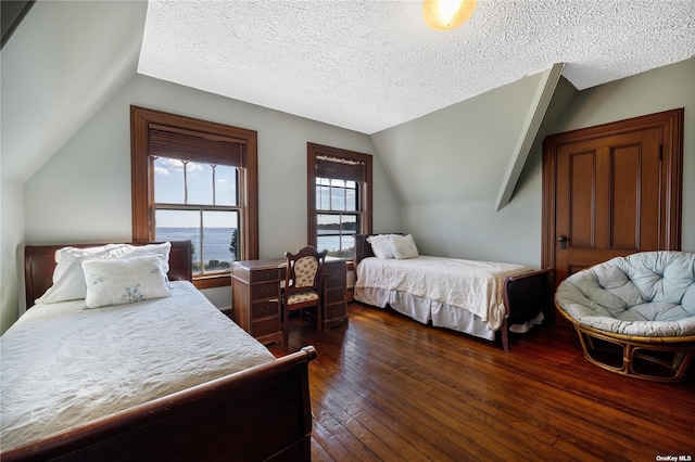 9 Convent Ln, Center Moriches, NY 11934 - bedroom with vaulted ceiling, dark wood-type flooring, and a textured ceiling