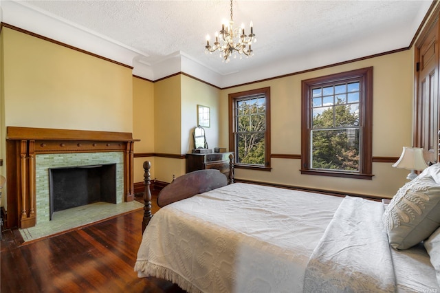 9 Convent Ln, Center Moriches, NY 11934 - bedroom featuring wood finished floors, a chandelier, a textured ceiling, ornamental molding, and a fireplace with flush hearth