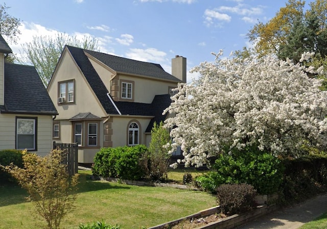 5 Garfield Pl, Roslyn Heights, NY 11577 - view of front of house featuring a chimney, stucco siding, a front lawn, and roof with shingles