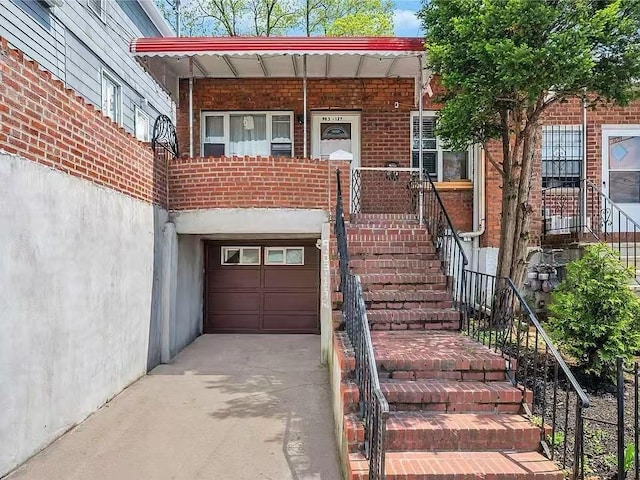 9-03 127th St, College Point, NY 11356 - property entrance with an attached garage, brick siding, and a porch
