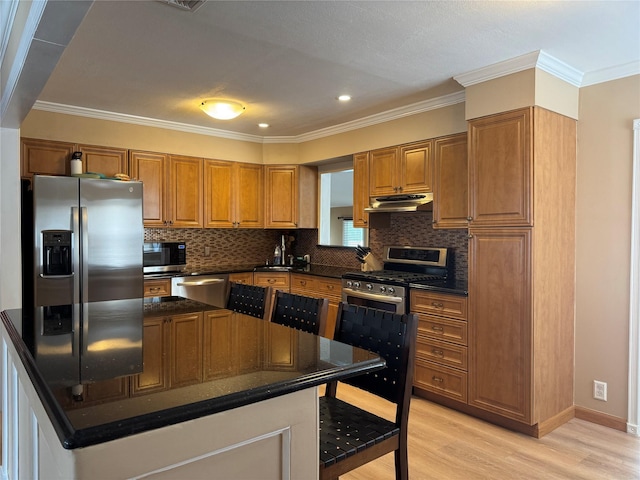 3805 Mansfield Dr, Seaford, NY 11783 - kitchen featuring stainless steel appliances, light wood finished floors, brown cabinetry, under cabinet range hood, and backsplash