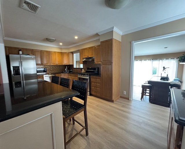 3805 Mansfield Dr, Seaford, NY 11783 - kitchen with appliances with stainless steel finishes, dark countertops, ornamental molding, light wood-type flooring, and tasteful backsplash