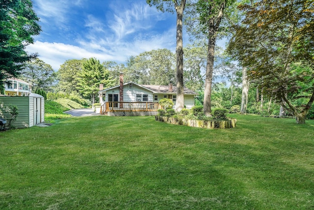 203 Deer Park Rd, Dix Hills, NY 11746 - view of green lawn featuring a storage unit, a deck, and view of wooded area