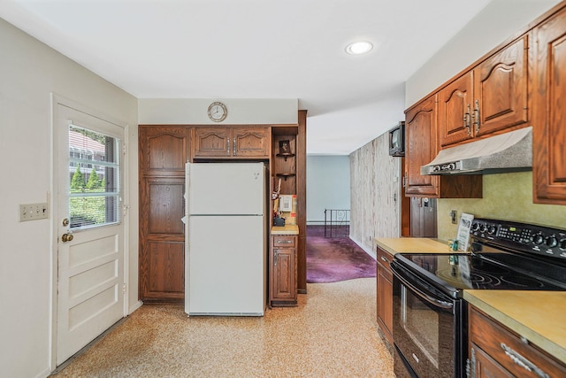 203 Deer Park Rd, Dix Hills, NY 11746 - kitchen with freestanding refrigerator, black electric range oven, under cabinet range hood, light countertops, and brown cabinets