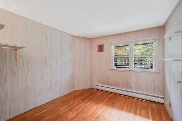 203 Deer Park Rd, Dix Hills, NY 11746 - unfurnished room with a baseboard heating unit, hardwood / wood-style flooring, and wooden walls