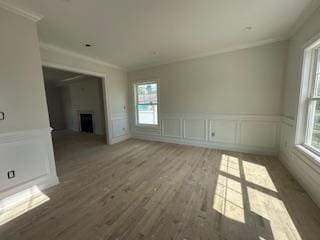 4 Kroll St, Plainview, NY 11803 - unfurnished living room featuring ornamental molding, light wood finished floors, a decorative wall, a wainscoted wall, and a fireplace