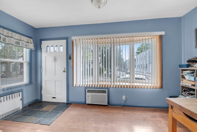 7609 79th St, Glendale, NY 11385 - foyer with radiator, a wall unit AC, and wood finished floors