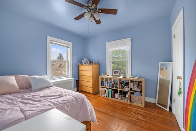 7609 79th St, Glendale, NY 11385 - bedroom with radiator heating unit, wood finished floors, and ceiling fan
