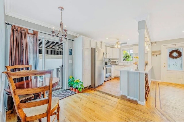 24 Lowerre St, Babylon, NY 11702 - kitchen with a peninsula, light wood-style flooring, light countertops, white cabinetry, and appliances with stainless steel finishes