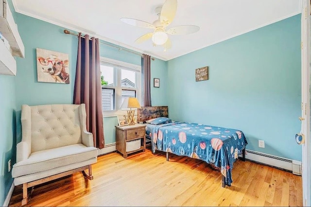24 Lowerre St, Babylon, NY 11702 - bedroom featuring crown molding, a baseboard heating unit, wood finished floors, and a ceiling fan