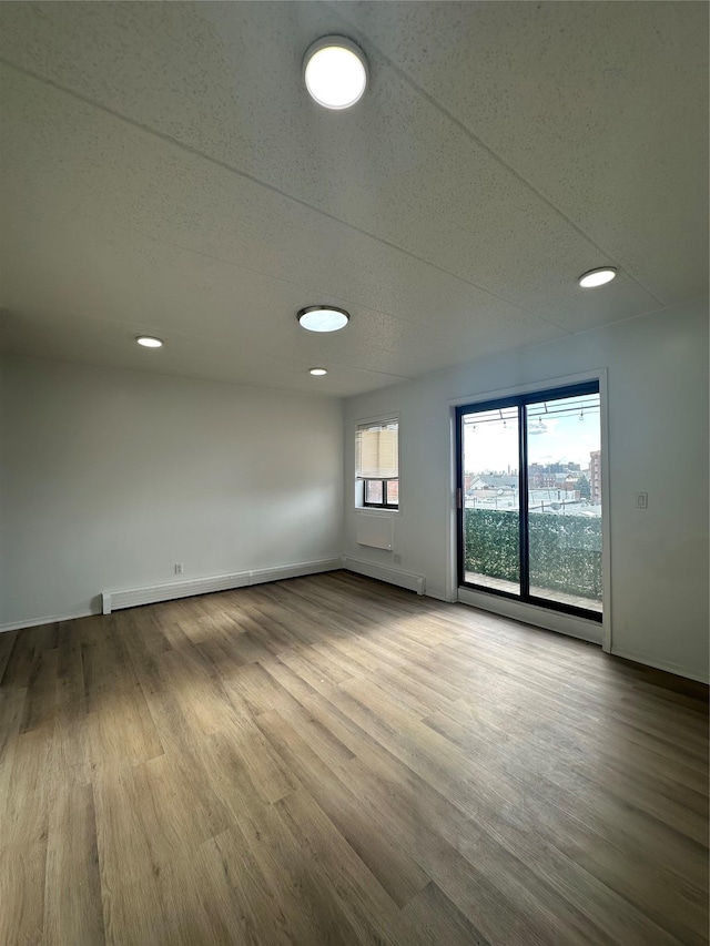41-28 71st St Unit 4D, Woodside, NY 11377 - spare room featuring wood finished floors, a baseboard heating unit, and recessed lighting