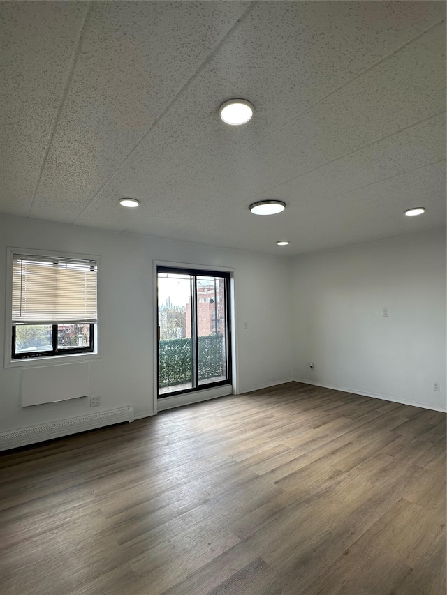 41-28 71st St Unit 4D, Woodside, NY 11377 - unfurnished room with wood finished floors, a baseboard radiator, and recessed lighting