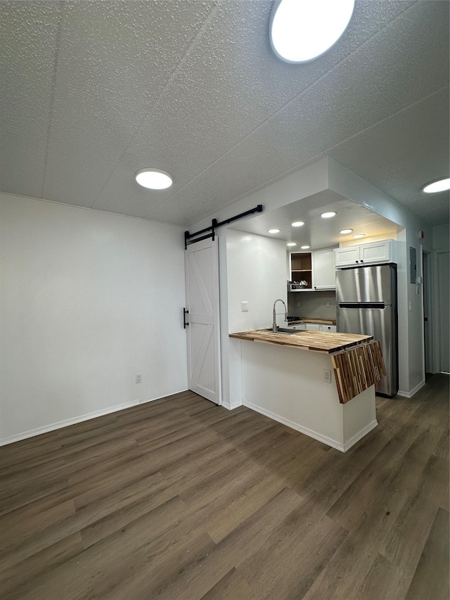 41-28 71st St Unit 4D, Woodside, NY 11377 - kitchen with freestanding refrigerator, wooden counters, a barn door, a peninsula, and dark wood-type flooring