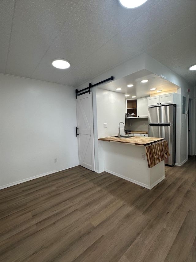 41-28 71st St Unit 4D, Woodside, NY 11377 - kitchen featuring freestanding refrigerator, wood counters, a barn door, a peninsula, and dark wood-style floors