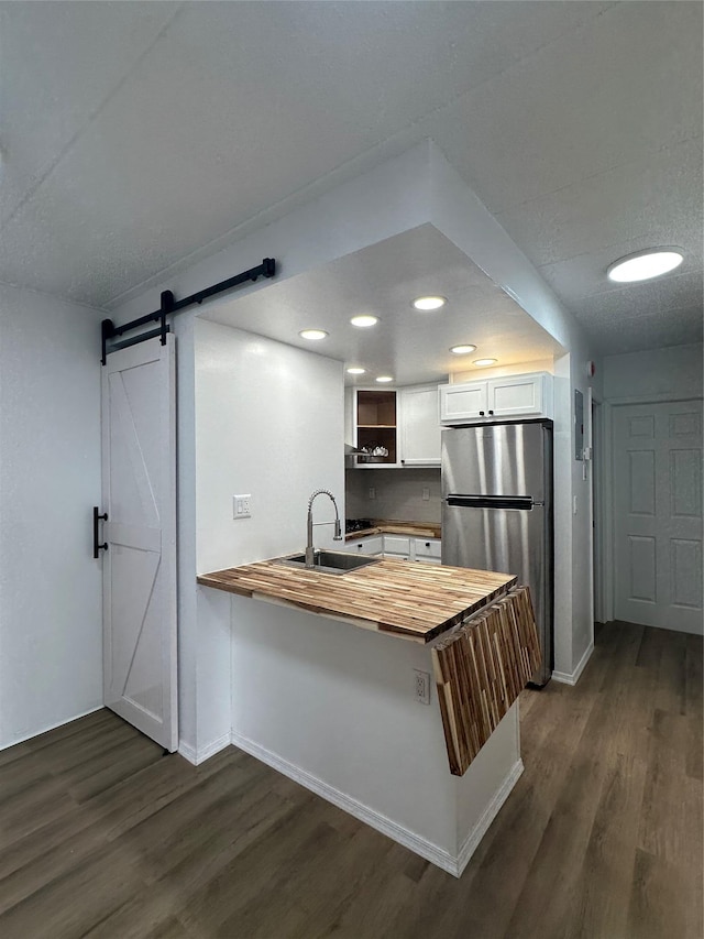 41-28 71st St Unit 4D, Woodside, NY 11377 - kitchen featuring butcher block counters, freestanding refrigerator, dark wood-type flooring, a peninsula, and a barn door