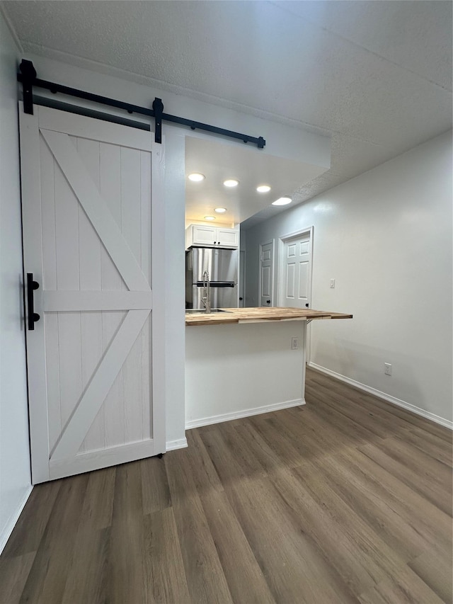 41-28 71st St Unit 4D, Woodside, NY 11377 - kitchen featuring freestanding refrigerator, dark wood finished floors, a barn door, a peninsula, and recessed lighting