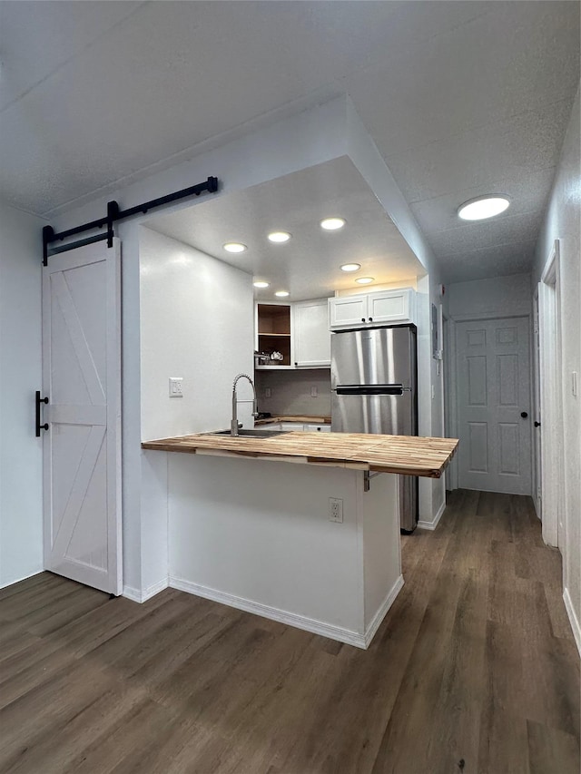 41-28 71st St Unit 4D, Woodside, NY 11377 - kitchen with wooden counters, freestanding refrigerator, dark wood-style flooring, a barn door, and recessed lighting