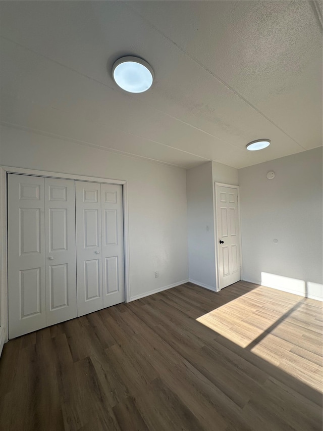 41-28 71st St Unit 4D, Woodside, NY 11377 - unfurnished bedroom featuring wood finished floors, a textured ceiling, and a closet
