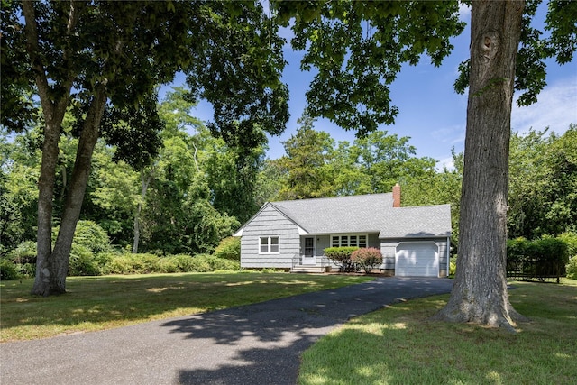 795 Pine Tree Rd, Cutchogue, NY 11935 - view of front facade featuring a chimney, a garage, driveway, and a front lawn