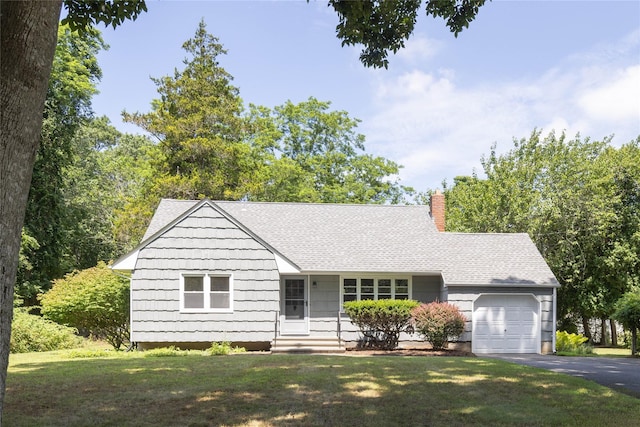 795 Pine Tree Rd, Cutchogue, NY 11935 - ranch-style home featuring an attached garage, a chimney, asphalt driveway, a front lawn, and roof with shingles